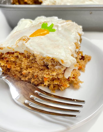 Slice of a Carrot Cake With Icing and Carrot Design Icing