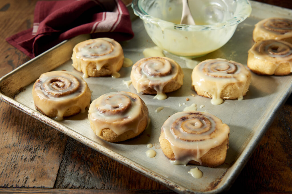 Cinnamon Rolls With Syrup Glazed on Top on A Baking Tray