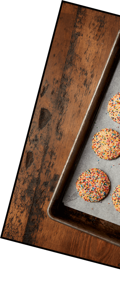 A baking tray with Sugar Cookies topped with sprinklers