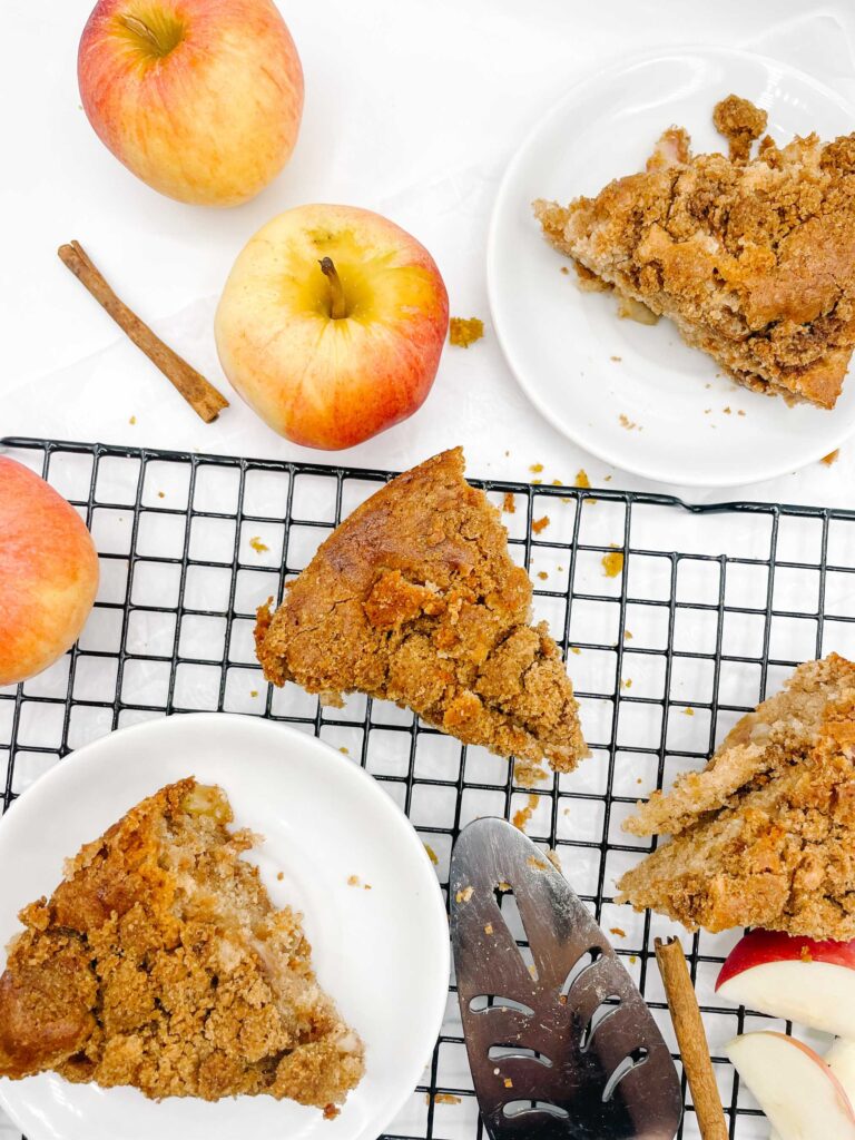 An apple cinnamon coffee cake with some whole apples